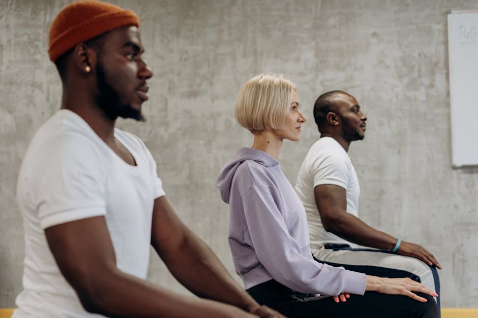 Diverse group of cheerful people sitting on yoga mats after a class